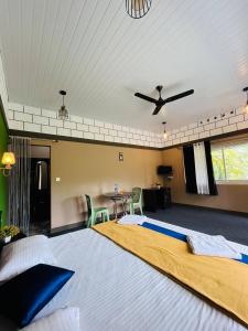 a bedroom with a large bed with a ceiling fan at Linn View Home Stay Munnar in Munnar +12 photos
