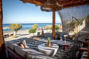 a living room with a couch and a view of the beach at Lapis Nera Villas - Beachfront & "Free" Heated Pools in Psari Forada