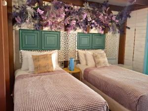 two beds with green headboards in a room at Bleu Verde, The Self Healing Hotel & Retreat in Gili Trawangan +111 photos
