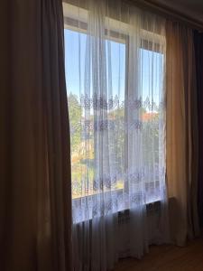 a window with white curtains in a room at Приватні апартаменти in Odesa