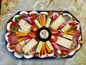 a plate of food with vegetables and dip on it at Tipi sous les étoiles in Lucéram
