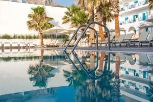 a resort swimming pool with a slide in the water at Kamari Beach Hotel in Kamari