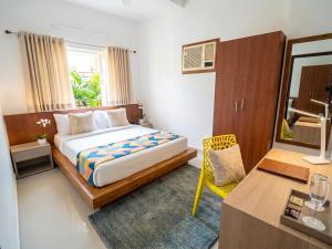 a bedroom with a bed and a table and a desk at Lake Land Guest House in Kolkata