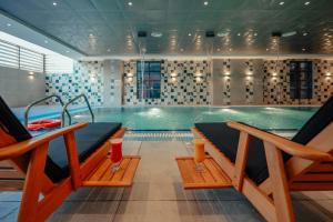 ein Schwimmbecken mit zwei Bänken davor in der Unterkunft Paradise Nice Hotel Jeddah in Dschidda