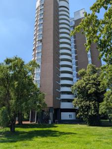 a tall building with a grass field in front of it at City Apartments Osnabrück - Balkon & Parken inklusive in Osnabrück