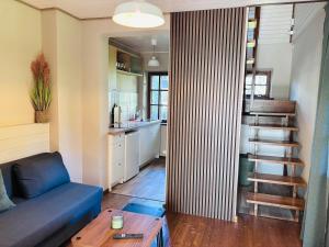 a living room with a blue couch and a kitchen at Võsula Tornimaja apartments in Võsu +6 photos