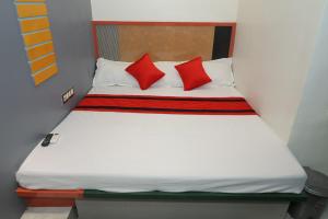 a bed in a room with red pillows on it at Hotel SR Imperial in Kolkata