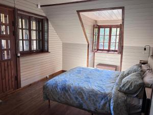 a bedroom with a bed and two windows at Võsula Tornimaja apartments in Võsu