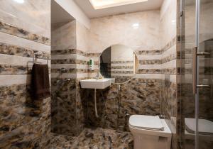 a bathroom with a toilet and a sink and a shower at Hotel SR Imperial in Kolkata