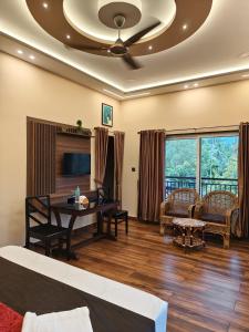 a room with a bed and a desk and a tv at Linn View Home Stay Munnar in Munnar