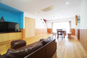 a living room with a couch and a television at 白浜みんと in Shirahama