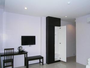 a room with a tv on the wall and a chair at Hotel Kawan in Tapah