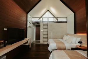 a hotel room with two beds and a tv at Grey Rock Mountain Cabin w/ Jacuzzi in Balamban