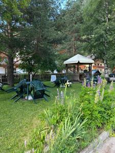 a park with picnic tables and a gazebo at Garnì La Zondra in Canazei