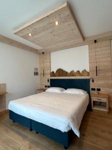 a bedroom with a large bed with a blue headboard at Garnì La Zondra in Canazei