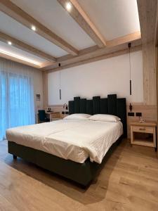 a bedroom with a large bed with a black headboard at Garnì La Zondra in Canazei