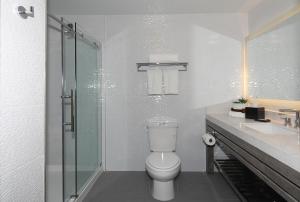 a bathroom with a toilet and a glass shower at Lexen Hotel - Hollywood in Los Angeles