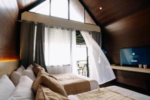 a bedroom with two beds and a window at Grey Rock Mountain Cabin w/ Jacuzzi in Balamban