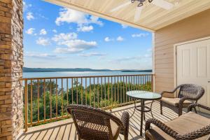 a balcony with chairs and a table and a view of the water at Smirnoff Pointe Lakefront in Hollister