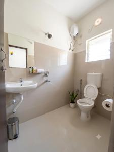 a bathroom with a toilet and a sink at Lake Land Guest House in Kolkata