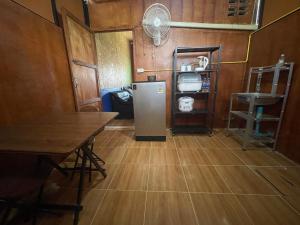 a kitchen with a refrigerator and a table and a fan at Lamai Home Koh Yao Noi in Ko Yao Noi +12 photos