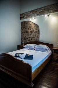 una camera con un grande letto con testiera in legno di Jason's Stone House ad Ágios Matthaíos