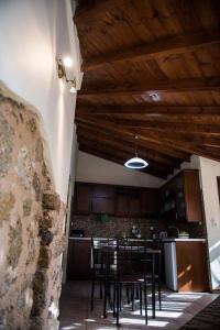 uma cozinha com cadeiras e uma mesa num quarto em Jason's Stone House em Ágios Matthaíos
