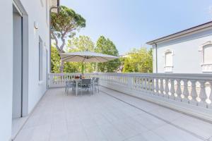 a patio with a table and an umbrella on a balcony at Villa Italia in Cesenatico
