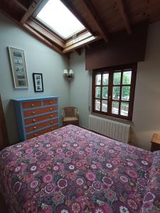 a bedroom with a large bed with a floral bedspread at La casuca in Noja