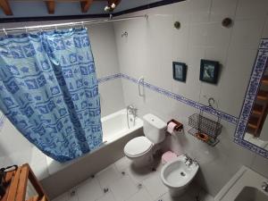 a bathroom with a toilet and a tub and a sink at La casuca in Noja