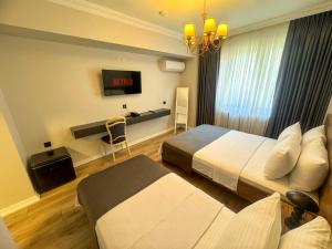 a hotel room with two beds and a tv at Fethibey Otel in Bartın