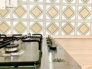 a stove top in a kitchen with a tile wall at Casalhouse in Furci Siculo