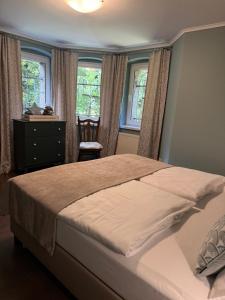 a bedroom with a bed and a dresser and windows at Decor Park Apartament in Karpacz