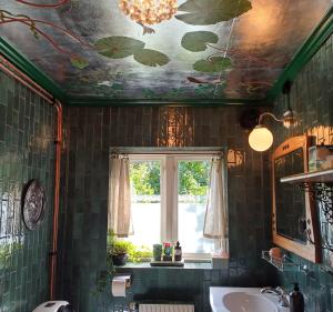 a bathroom with a ceiling with leaves painted on it at Villagatan in Hjo