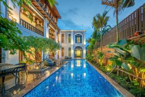 a swimming pool in a villa with a house at At Tree Hotel Thaphae Gate Chiangmai in Chiang Mai