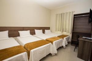 מיטה או מיטות בחדר ב-Recanto Hotel Clube