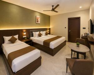 a hotel room with two beds and a table at Hotel S-mart In Delhi Airport & Free Airport Pickup in New Delhi