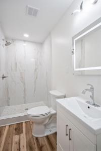 a white bathroom with a toilet and a sink at Clair de Lune Studio A Charming Kokomo Stay in Kokomo