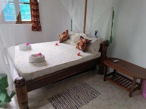 a bedroom with a bed with a canopy and a table at Jambiani Holiday House in Jambiani