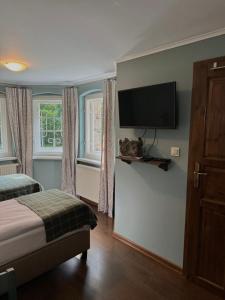 a bedroom with a bed and a flat screen tv at Decor Park Apartament in Karpacz