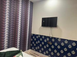 a bedroom with a tv on the wall and a bed at Aone Hotel Quetta in Quetta +12 photos