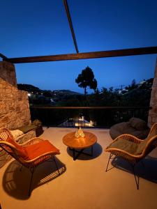 a patio with two chairs and a table and a window at Noema Seaside in Dhaskalión