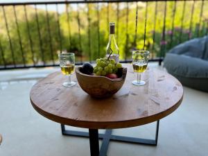 a table with a bowl of fruit and two wine glasses at Noema Seaside in Dhaskalión