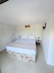 a bedroom with a large bed in a white room at Noema Seaside in Dhaskalión