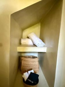 a shelf with towels and a basket on it at Noema Seaside in Dhaskalión +17 photos