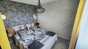 a bedroom with a bed and a brick wall at Au Barthas in Caylus