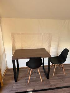 a wooden table with two black chairs around it at simami resort in Caldarola