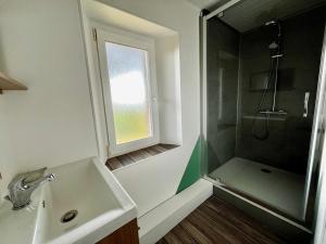 a bathroom with a sink and a shower with a window at Le Nid de Réville, Maison proche de la mer in Réville +18 photos