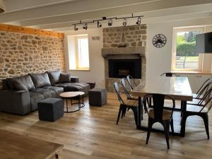a living room with a couch and a table at Le Nid de Réville, Maison proche de la mer in Réville