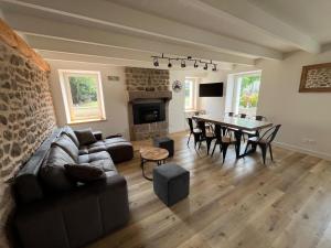 a living room with a couch and a table at Le Nid de Réville, Maison proche de la mer in Réville